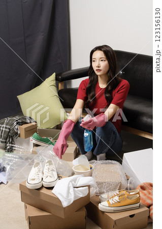 A young man in his 20s cleaning his room wearing rubber gloves A young man in his 20s cleaning his room wearing rubber gloves 123156130
