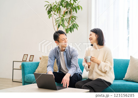 パソコンのモニターを見ながら笑談する夫婦 パソコンのモニターを見ながら笑談する夫婦 123156285