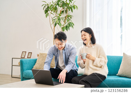 パソコンのモニターを見ながら笑談する夫婦 123156286