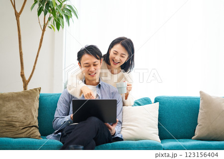 パソコンのモニターを見ながら笑談する夫婦 123156404