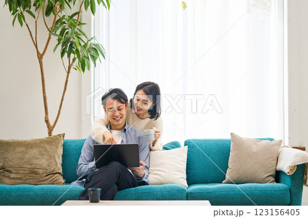 パソコンのモニターを見ながら笑談する夫婦 123156405