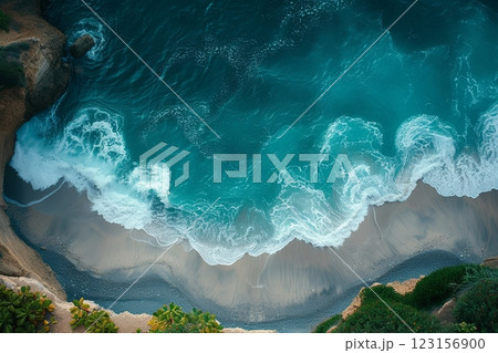 Ocean is calm and the waves are small. The beach is rocky and the water is blue. Aerial view 123156900