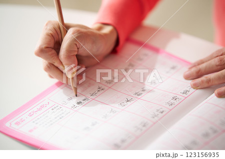 漢字の書取りをする中年女性 123156935