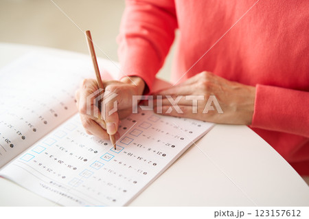 計算ドリルを解く中年女性 123157612