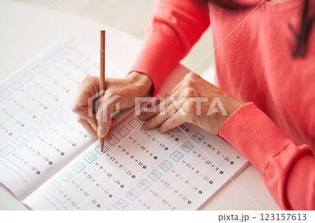 計算ドリルを解く中年女性 計算ドリルを解く中年女性 123157613