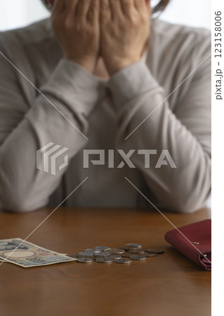 財布に残った現金をテーブルにばら撒く　自然光 123158006