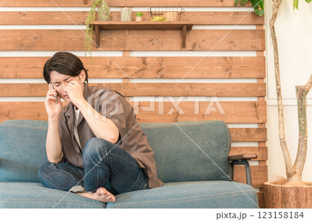 スマホで通話する若いアジア人男性(泣く・悲しい・別れ話・涙・謝る・女々しい・落ち込む) スマホで通話する若いアジア人男性(泣く・悲しい・別れ話・涙・謝る・女々しい・落ち込む) 123158184