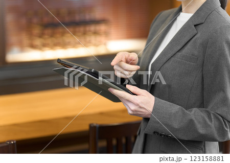 飲食店でタブレットを見るスーツを着た女性 123158881