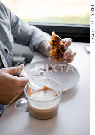 Adult male enjoying pastry and coffee in casual setting Adult male enjoying pastry and coffee in casual setting 123159861