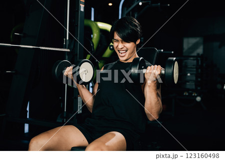 Asian man muscular lifting dumbbell on bench in fitness gym, Happy young men doing strength training press exercise with dumbbells in a gym, workout weight training healthy lifestyle concept Asian man muscular lifting dumbbell on bench in fitness gym, Happy young men doing strength training press exercise with dumbbells in a gym, workout weight training healthy lifestyle concept 123160498
