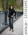 Age model woman 51 years old, brunette with loose hair, stands in a podium pose 123161445