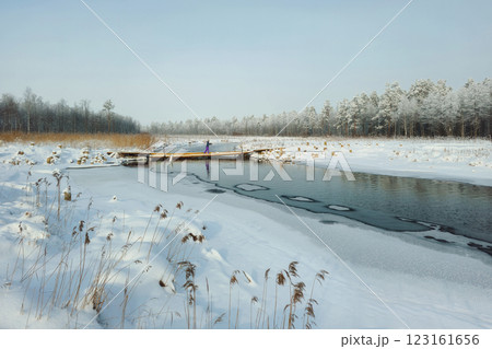 Snow and old wooden bridge over the river. Snow and old wooden bridge over the river. 123161656
