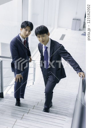 オフィスビルの階段に立つ若いビジネスマン2人のポートレート 縦位置 オフィスビルの階段に立つ若いビジネスマン2人のポートレート 縦位置 123162002