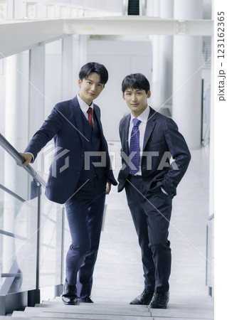 オフィスビルの階段に立つ若いビジネスマン2人のポートレート　縦位置 123162365