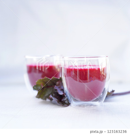 A cup of fresh beetroot juice with leaves on table. 123163236