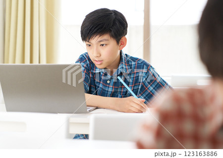 真剣な表情で勉強中の高学年男子 真剣な表情で勉強中の高学年男子 123163886