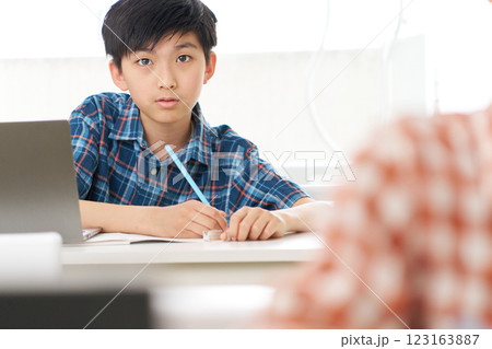 真剣な表情で勉強中の高学年男子 123163887