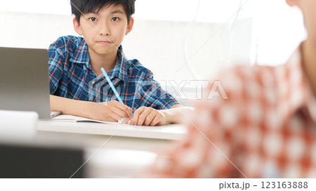 真剣な表情で勉強中の高学年男子 123163888