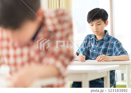 真剣な表情で勉強中の高学年男子 123163892