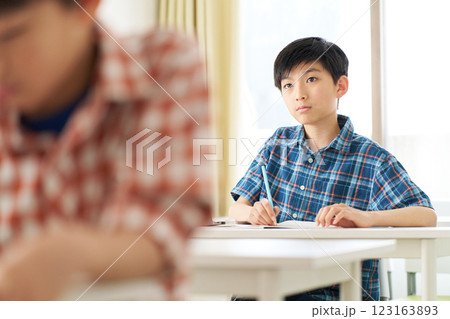 真剣な表情で勉強中の高学年男子 123163893