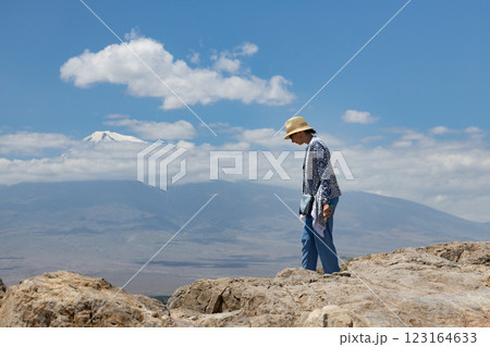 Exploring rocky landscapes beneath a vast sky with distant snow-capped mountains in bright daylight Exploring rocky landscapes beneath a vast sky with distant snow-capped mountains in bright daylight 123164633