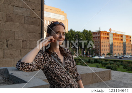 Woman enjoying a sunny day in a lively urban park surrounded by historical architecture in Yerevan 123164645
