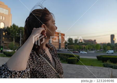 Captivating woman enjoys sunset view in vibrant cityscape during warm summer evening Captivating woman enjoys sunset view in vibrant cityscape during warm summer evening 123164646