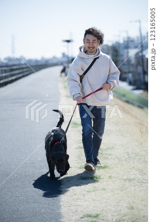 河川敷で大型犬の散歩を楽しむ男性 河川敷で大型犬の散歩を楽しむ男性 123165005