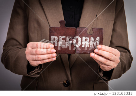 REFORM Concept. Business woman with wooden puzzle pieces 123165333