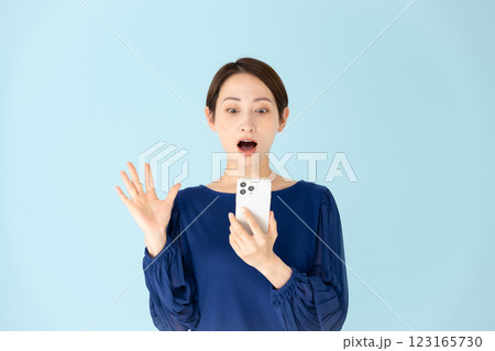 女性　カジュアル　ポートレート　スマホ　驚く 123165730