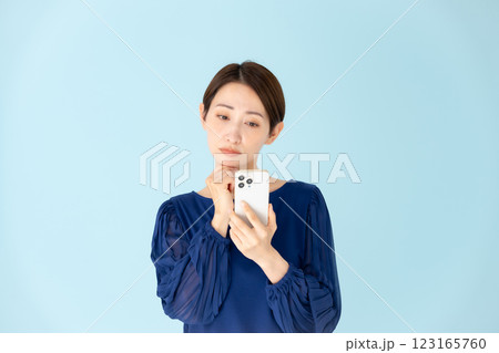 女性　カジュアル　ポートレート　スマホ　悩む 123165760