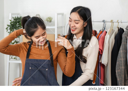 Cheerful fashion designers collaborating on clothing display in a stylish boutique Cheerful fashion designers collaborating on clothing display in a stylish boutique 123167344