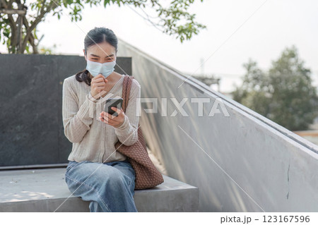 Smiling woman using smartphone while managing pollution discomfort 123167596