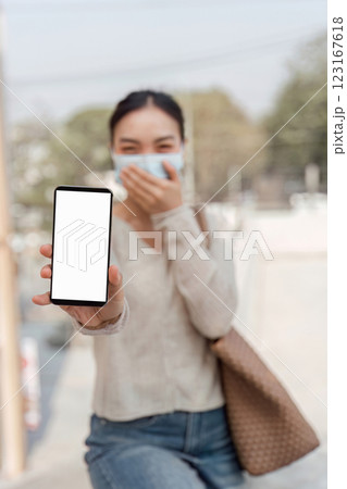 Young woman holding smartphone, showing discomfort from pollution 123167618