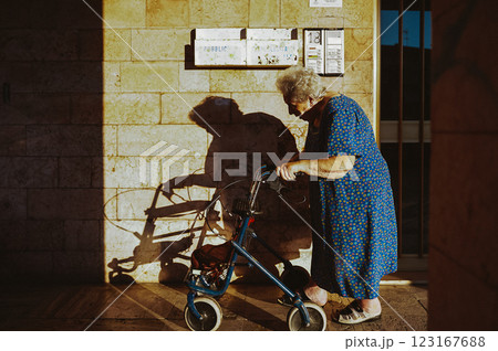 Old woman went outside to walk with help of walker Old woman went outside to walk with help of walker 123167688