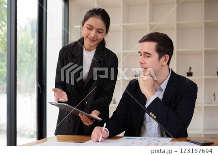 Two businessmen discussing project at the office room Businessman discusses project planning with colleagues in modern workplace while having discussion and advice on financial data report. Two businessmen discussing project at the office room Businessman discusses project planning with colleagues in modern workplace while having discussion and advice on financial data report. 123167694
