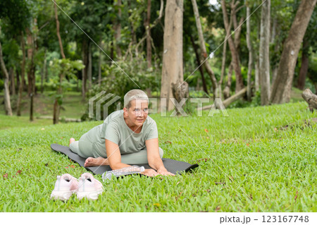 Elderly Woman Practicing Yoga Outdoors in a Peaceful Park Setting, Embracing Wellness and Flexibility in Nature 123167748