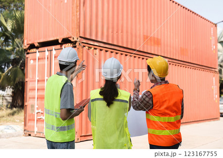 Construction team discussing logistics and planning strategies at a site with shipping containers 123167755