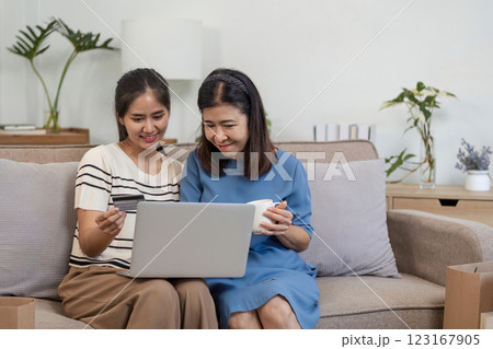 Mother and Child Enjoying Online Shopping Together with Credit Card on Laptop in Cozy Home Environment 123167905