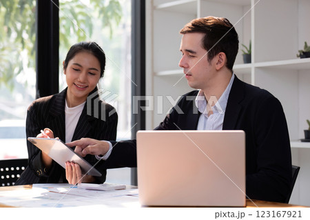 Two businessmen discussing project at the office room Businessman discusses project planning with colleagues in modern workplace while having discussion and advice on financial data report. 123167921