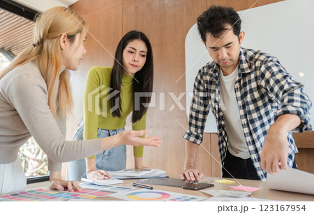 Diverse team collaborating on design project in modern office workspace. Diverse team collaborating on design project in modern office workspace. 123167954