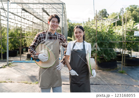 Couple Cultivating a Cannabis Herb Garden Together in a Modern Greenhouse Setting with Sustainable Gardening Techniques 123168055