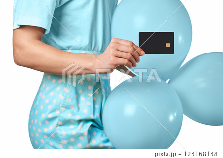 Caucasian female hand holding black premium credit bank card and blue festive air balloons on white background. digital business finance Caucasian female hand holding black premium credit bank card and blue festive air balloons on white background. digital business finance 123168138
