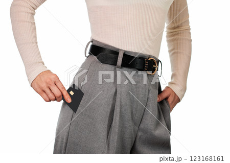 Caucasian female hand putting black premium credit bank card in grey pants pocket on white background. Money finance 123168161