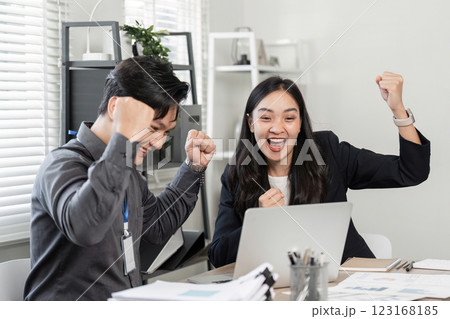 Diverse business partners celebrating team victory with excitement in the office. 123168185