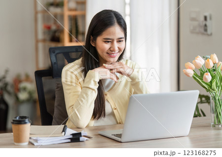 Freelance businesswoman working from home, engaging with clients on a laptop, showcasing productivity and focus. 123168275