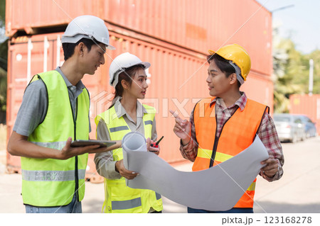 Construction professionals discussing blueprints and site plans while collaborating at a project location 123168278