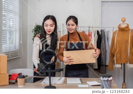 Couple selling clothes online, coordinating product display and packaging in their modern home office Couple selling clothes online, coordinating product display and packaging in their modern home office 123168283