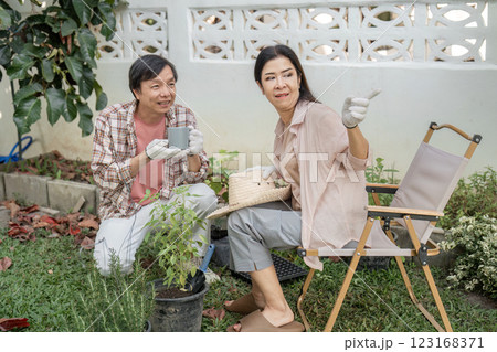 Diverse couple discussing gardening ideas in a sunny backyard, sharing smiles. 123168371