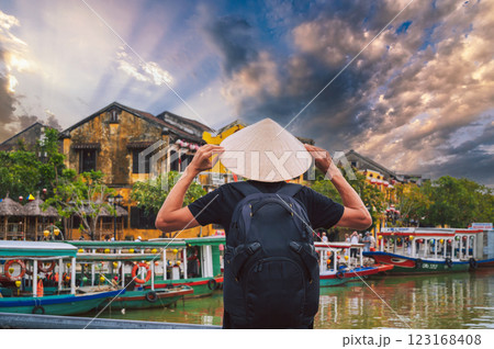 back of male tourist traveler in Vietnamese hat on a bridge in old town in Hoi An in Vietnam in Asia back of male tourist traveler in Vietnamese hat on a bridge in old town in Hoi An in Vietnam in Asia 123168408